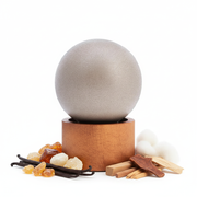 Frasco de perfume esférico minimalista con ingredientes naturales