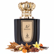 Frasco Shaula de Nojoum Dubai EDP, botella rectangular negra brillante con placa dorada grande y borde punteado, caligrafía árabe شولا y texto SHAULA NOJOUM DUBAI en oscuro, cuello dorado acanalado, tapa corona real ornamentada en oro brillante, rodeado de hoja de tabaco, jengibre, especias, tonka, flor de tabaco, vainilla, cacao, frutas secas y maderas.
