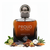 Frasco Proud of You Absolute de Fragrance World EDP, botella cuadrada con esquinas muy redondeadas en vidrio degradado ámbar-coñac a negro profundo, texto plateado PROUD OF YOU ABSOLUTE y logo globo Fragrance World, collar cristal facetado plateado ancho en los hombros, cuello cilíndrico plateado con textura knurling, tapa esfera grande cromo pulido con punto oscuro central, rodeado de bergamota, cardamomo, pimienta, lavanda, salvia, cuero, canela, tonka, almizcle, vainilla y amberwood.