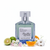 Frasco Barakkat Aqua Stellar de Fragrance World EDP, botella octagonal facetada en vidrio transparente con tinte aqua azul pálido, etiqueta rectangular blanca con borde plateado y texto oscuro Maison Eau De Parfum Vaporisateur más script Barakkat Aqua Stellar, bomba spray cromo, tapa cuadrada grande en cristal transparente, sobre fondo blanco, rodeado de bergamota, guisante de olor, naranja y almizcle blanco.