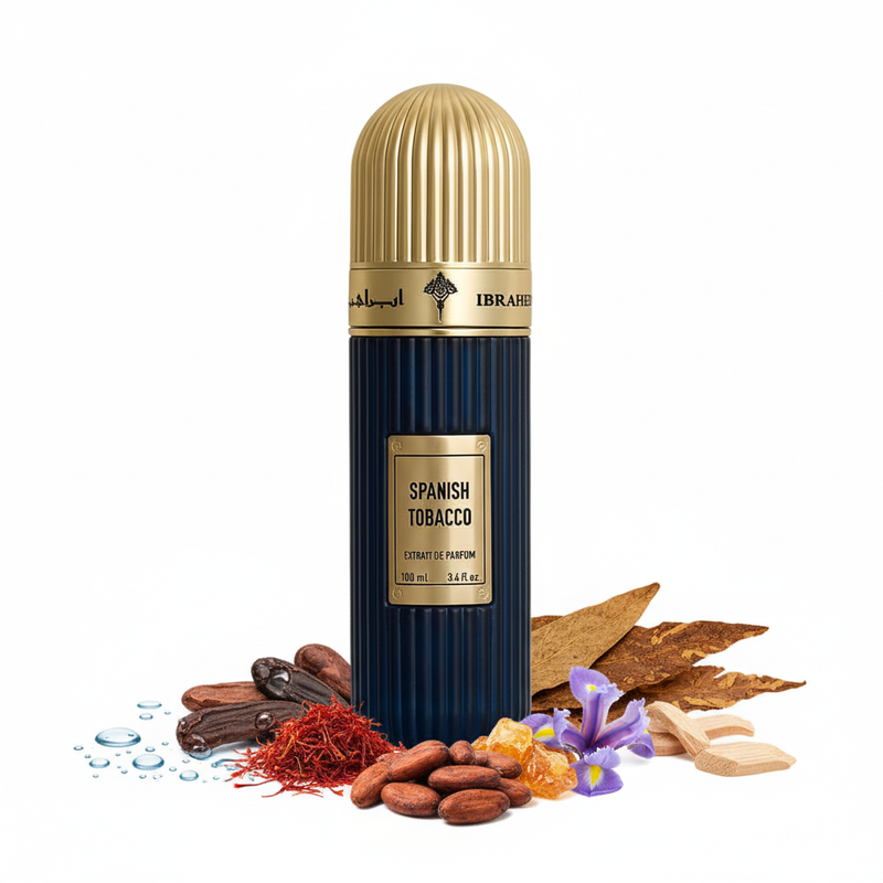 Frasco Spanish Tobacco Extrait de Parfum de Ibrahem, botella cilíndrica acanalada en azul marino oscuro brillante, placa cuadrada dorada con texto SPANISH TOBACCO EXTRAIT DE PARFUM y remaches en esquinas, banda dorada con caligrafía árabe ابراهيم e IBRAHEM, tapa cúpula acanalada dorada alta, sobre fondo blanco, rodeado de notas acuáticas, haba tonka, azafrán, cacao, ámbar, tabaco, iris y maderas.