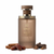 Frasco Timeless Joy de Liwan EDP, botella cilíndrica alta en vidrio esmerilado taupe-marrón cálido con acanalado vertical profundo, logo monograma LI dorado pequeño, texto dorado LIWAN TIMELESS JOY, banda collar multi-anillo dorado prominente, cuello dorado corto, tapa cilíndrica ancha taupe-marrón mate con anillo dorado en la base, rodeado de canela, dátiles y oud.