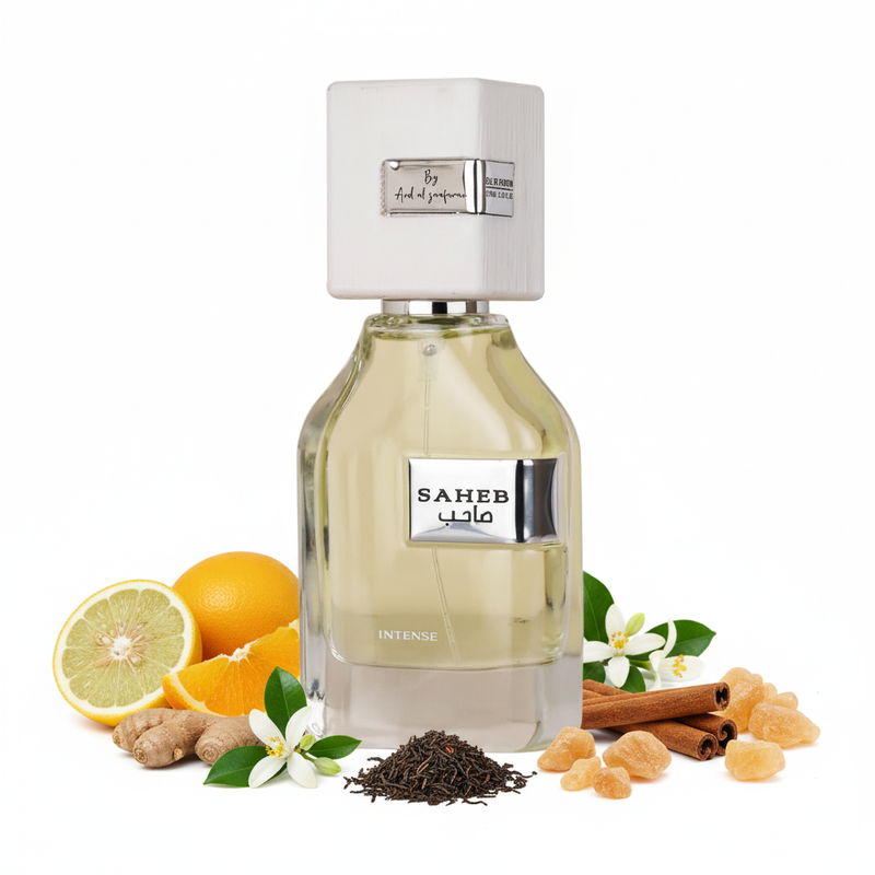 Frasco Saheb Intense de Ard Al Zaafaran EDP, botella cuadrada redondeada vidrio transparente, placa plateada SAHEB صاحب, texto INTENSE en vidrio, tapa cuadrada blanca mate con placas By Ard al zaafaran y EAU DE PARFUM, sobre fondo blanco, rodeado de cidra, bergamota, naranja siciliana, jengibre, neroli, canela, té negro, ambroxan, madera de gaiac e incienso.