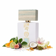 Frasco Boccasile de Voci Giardini di Toscana, botella rectangular blanca mate con banda botánica dorada de higuera, medallón dorado y etiqueta azul-menta, tapa madera driftwood azul-gris, sobre fondo blanco, rodeado de naranja, bergamota, higuera, limón, muguete, magnolia, coco, melón, ámbar, cedro, musgo de roble y vetiver.