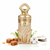 Frasco de perfume Noor de Lattafa, botella attar árabe ornamental con base soporte dorada en forma de alas, cuerpo cilíndrico crema-marfil perlado con textura espiral, banda etiqueta dorada con caligrafía árabe نور y texto NOOR, sección tapa dorada con grabado diamante knurling y asa loop rombo dorada en la cima, sobre fondo blanco, rodeado de caramelo, leche, lirio de los valles, vainilla y almizcle.