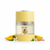 Frasco Sun Eau de Parfum de Al Majed Oud, diseño cilíndrico con tapa y base en amarillo mantequilla mate con borde superior festoneado, sección central en vidrio cristal transparente con texto dorado SUN EAU DE PARFUM, esfera dorada central y logo Al Majed Oud, banda central plateada martillada, sobre fondo blanco, rodeado de mango, flor de azahar y sándalo.