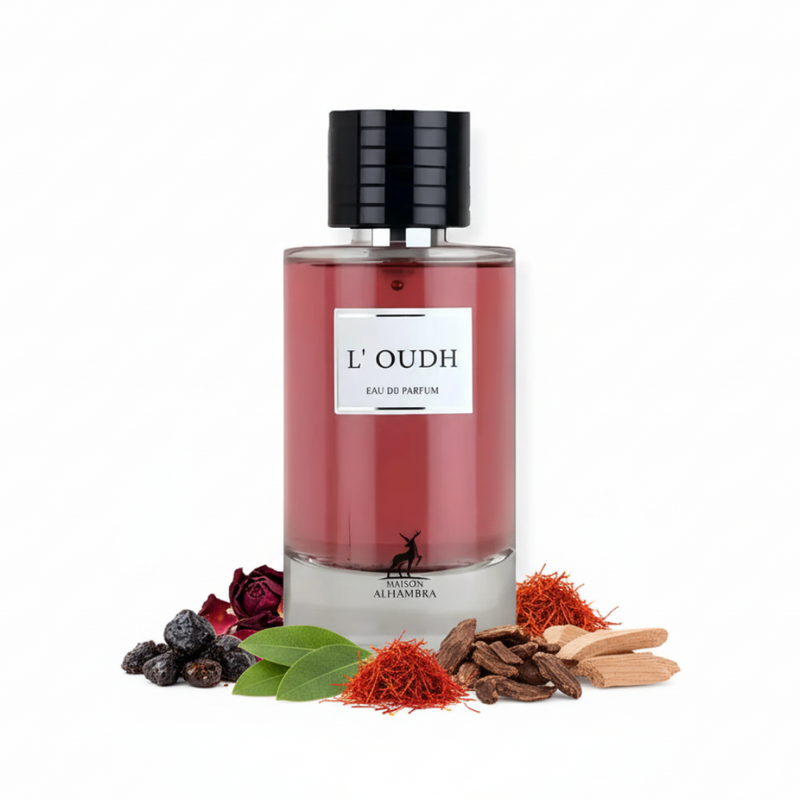Frasco de perfume L'Oudh de Maison Alhambra EDP 100ml, botella cilíndrica de vidrio transparente con líquido rosa-rojo, etiqueta blanca minimalista y tapón negro acanalado, sobre fondo blanco, rodeado de ládano, pétalos de rosa, pachulí, azafrán, madera de oud, sándalo y cedro.